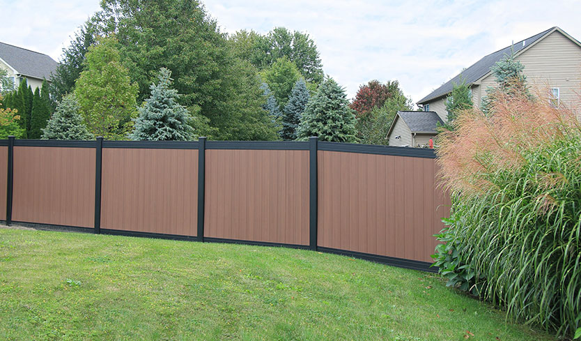 Two-tone composite privacy fence along a backyard