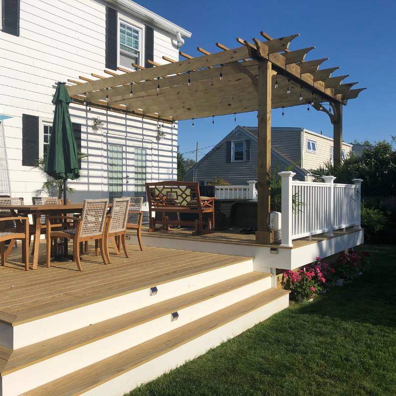 Pressure-treated deck with pergola, stairs and white railings